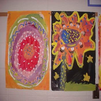 Picture of the students' paintings hanging on a wall.